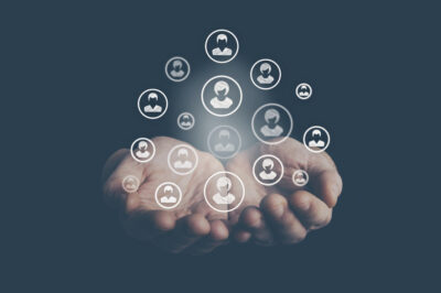 Hände über denen Icons mit Figuren entstehen.