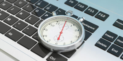 Stoppuhr liegt auf Laptop.