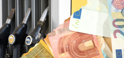 Euro Geldscheine und Zapfsäule an der Tankstelle.
