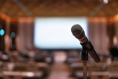 Mikrofon in Konferenzraum mit Leinwand.