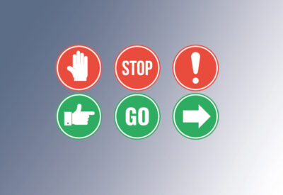Rotes Schild mit der Aufschrift Stop. Darunter ein grünes Schild mit der Aufschrift Go.