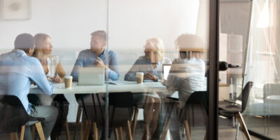 Fünf Personen diskutieren in einem Besprechungszimmer.