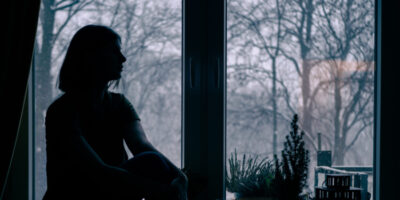 Silhouette einer Frau vor einem Fenster.